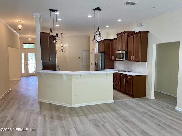 188 Irish Rose Rd, Saint Augustine, FL 32092 - kitchen featuring crown molding, stainless steel appliances, light wood-style flooring, and a breakfast bar area