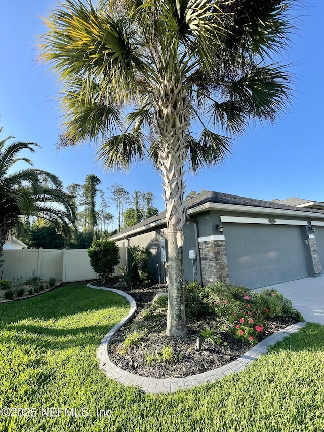 188 Irish Rose Rd, Saint Augustine, FL 32092 - view of front of property with driveway, fence, a garage, stone siding, and a front yard