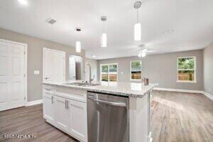 kitchen with baseboards, open floor plan, and dishwasher