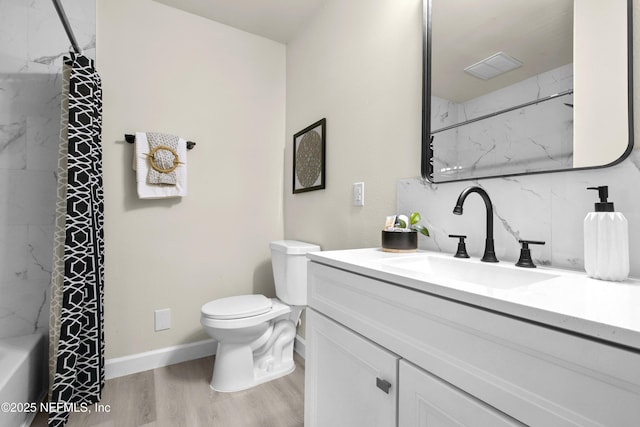 bathroom featuring vanity, baseboards, toilet, and wood finished floors
