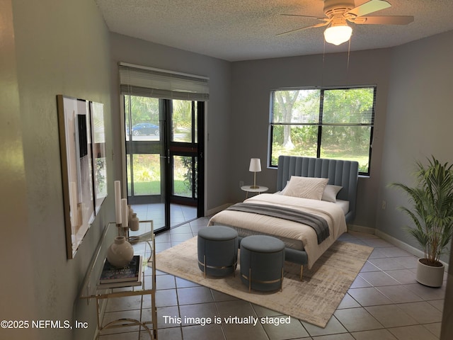 tiled bedroom featuring baseboards, a ceiling fan, and a textured ceiling
