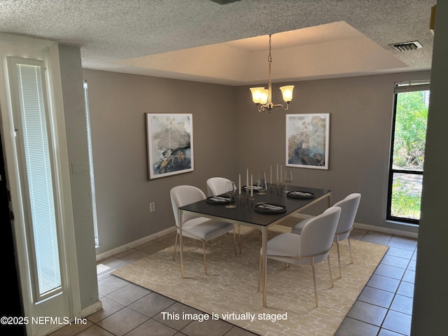 dining area featuring a notable chandelier, a textured ceiling, baseboards, light tile patterned floors, and visible vents