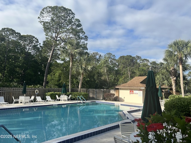 community pool featuring fence and a patio