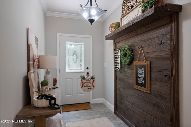 doorway to outside with crown molding, light wood-style floors, and baseboards