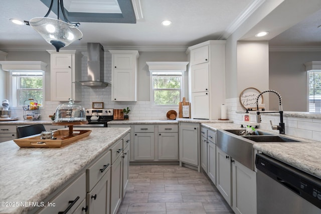 kitchen featuring appliances with stainless steel finishes, a healthy amount of sunlight, a sink, and wall chimney exhaust hood