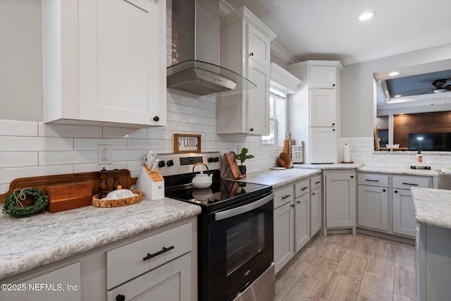 kitchen featuring wall chimney range hood, crown molding, tasteful backsplash, electric stove, and recessed lighting