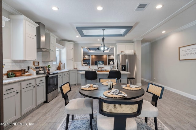 dining space featuring crown molding, visible vents, a raised ceiling, and light wood-type flooring