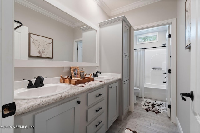 full bath with double vanity, toilet, ornamental molding, and a sink