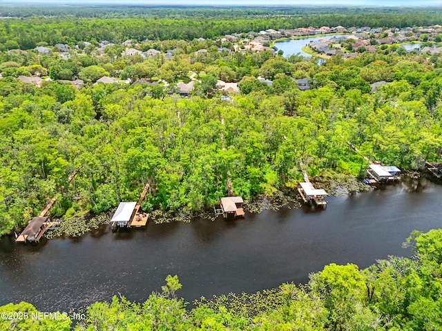 drone / aerial view of a heavily wooded area and a large body of water