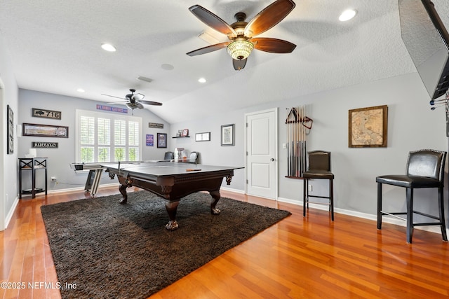 playroom featuring a ceiling fan, lofted ceiling, light wood finished floors, baseboards, and a textured ceiling