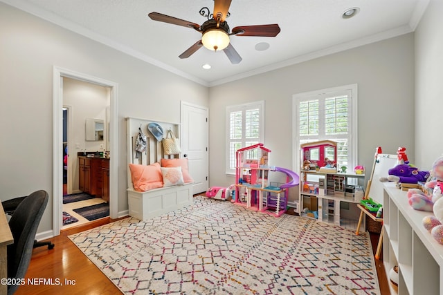 rec room with a ceiling fan, ornamental molding, wood finished floors, and recessed lighting