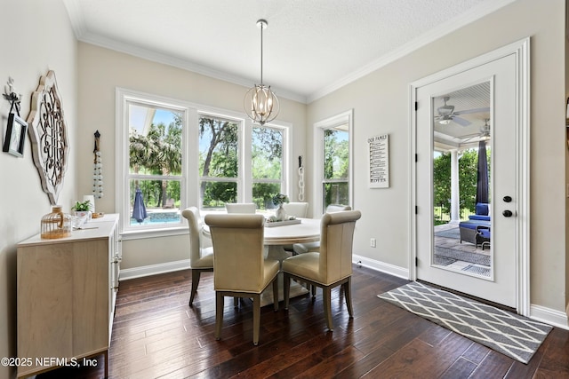 dining room featuring baseboards, dark wood-style flooring, a chandelier, ornamental molding, and a ceiling fan