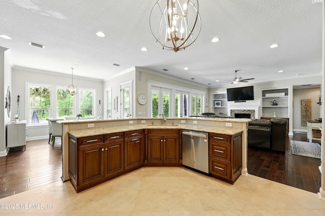 kitchen featuring stainless steel dishwasher, ornamental molding, a chandelier, a brick fireplace, and ceiling fan