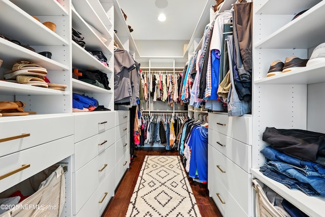 walk in closet with dark wood-style flooring