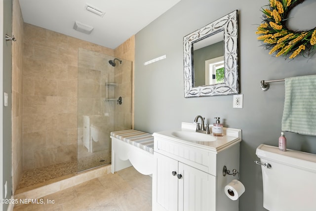 bathroom featuring toilet, tiled shower, vanity, and tile patterned flooring