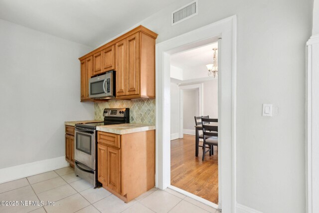 4949 Fremont St, Jacksonville, FL 32210 - kitchen featuring visible vents, an inviting chandelier, light countertops, appliances with stainless steel finishes, and light tile patterned floors