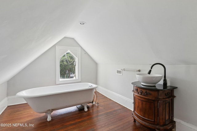 4949 Fremont St, Jacksonville, FL 32210 - full bathroom with baseboards, vaulted ceiling, a soaking tub, and wood finished floors