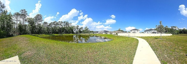 view of community with a water view, fence, and a yard