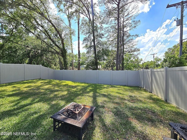 view of yard featuring a fenced backyard and an outdoor fire pit