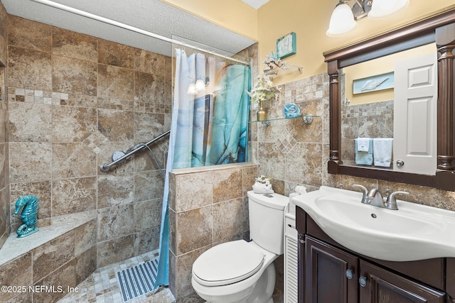 bathroom with vanity, tile walls, a tile shower, and toilet