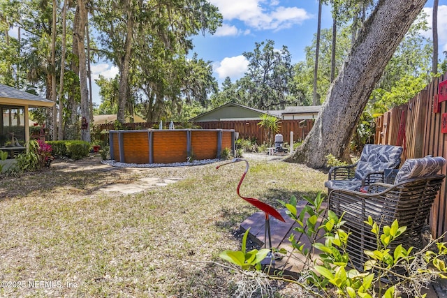 view of yard featuring a fenced backyard and a pool