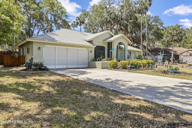 single story home with driveway, roof with shingles, a garage, fence, and stucco siding