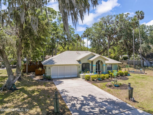 ranch-style house with fence, a garage, stucco siding, a front yard, and concrete driveway
