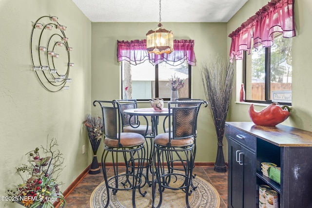 dining room with baseboards and a notable chandelier