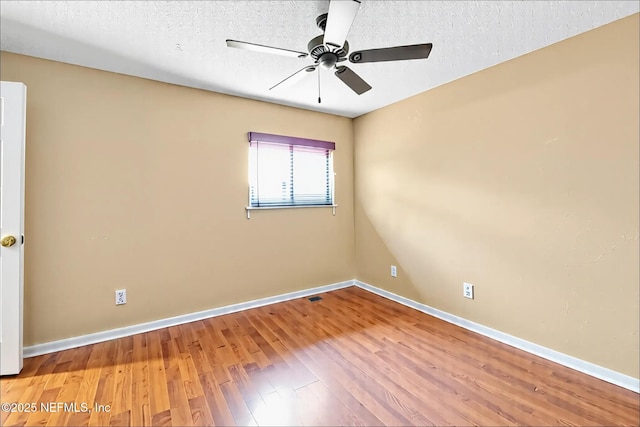 unfurnished room with baseboards, a textured ceiling, ceiling fan, and wood finished floors