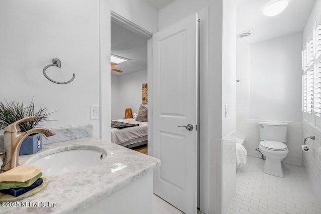 2325 Seminole Rd, Atlantic Beach, FL 32233 - bathroom with vanity, toilet, tile walls, ensuite bathroom, and tile patterned floors