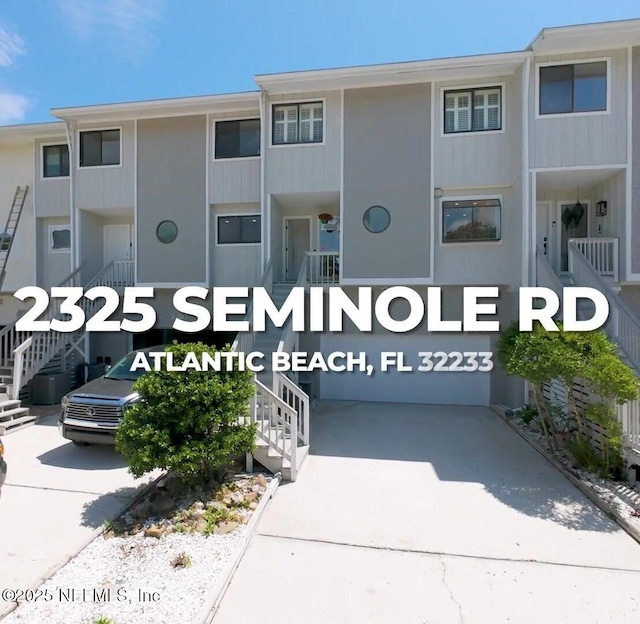 2325 Seminole Rd, Atlantic Beach, FL 32233 - view of building exterior featuring concrete driveway, stairs, and an attached garage