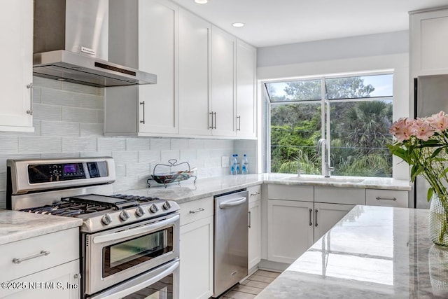 2325 Seminole Rd, Atlantic Beach, FL 32233 - kitchen featuring a sink, wall chimney exhaust hood, decorative backsplash, light stone countertops, and appliances with stainless steel finishes