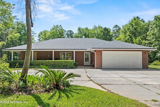 ranch-style home featuring a garage, concrete driveway, brick siding, and a shingled roof