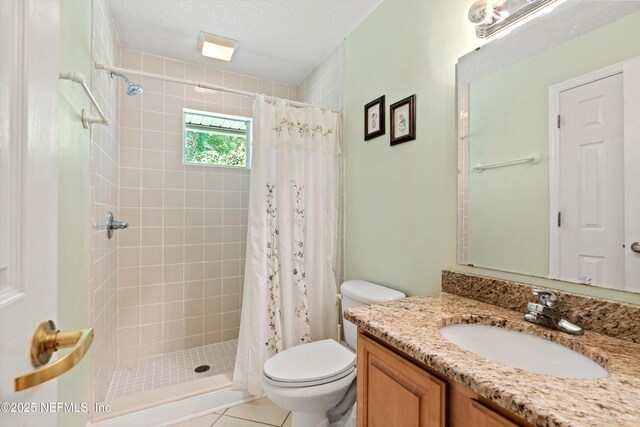 bathroom featuring toilet, a shower stall, vanity, and a textured ceiling