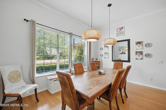 dining room with baseboards, ornamental molding, and light wood-style floors
