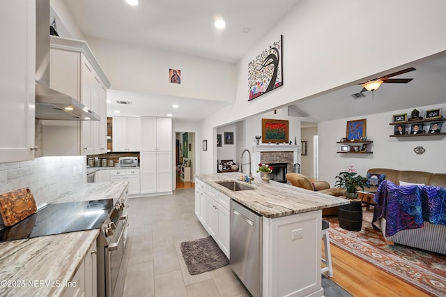 kitchen with a sink, stainless steel appliances, white cabinetry, and open floor plan