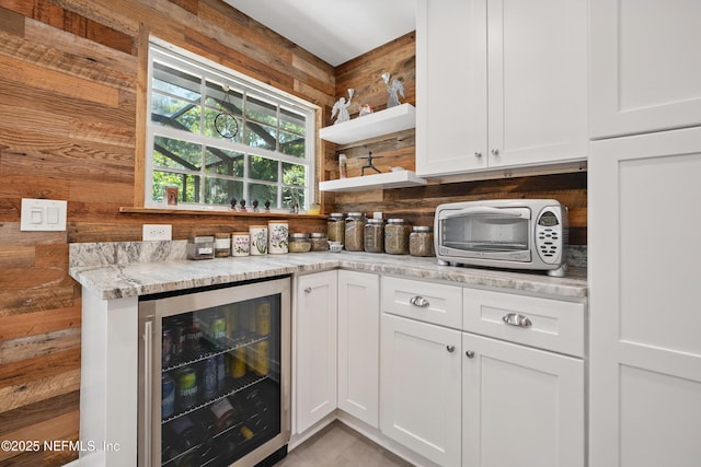 bar featuring backsplash, wood walls, a toaster, a bar, and beverage cooler