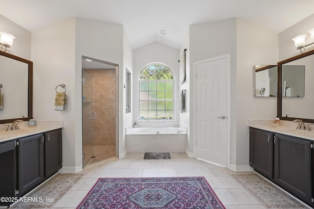 bathroom with vaulted ceiling, a shower stall, a sink, and a garden tub