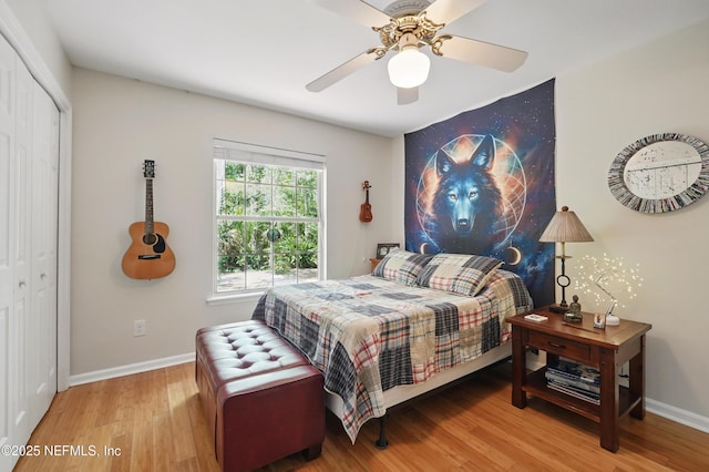 bedroom with baseboards, ceiling fan, wood finished floors, and a closet
