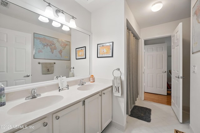 full bathroom featuring double vanity, baseboards, visible vents, and a sink
