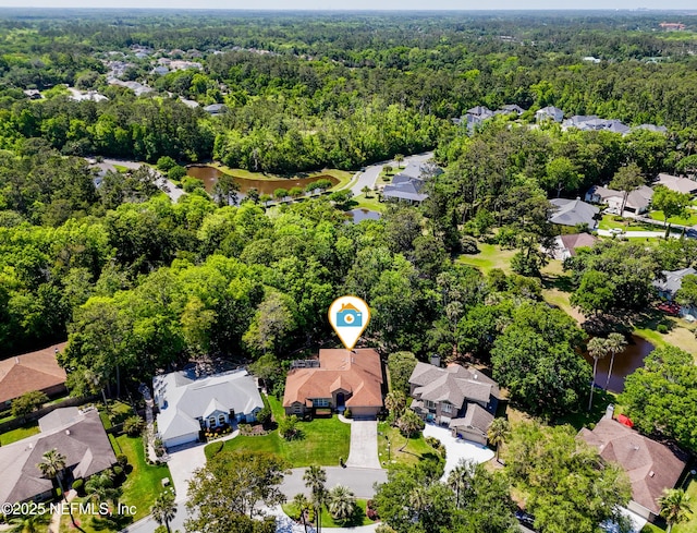 aerial view featuring a residential view, a water view, and a wooded view