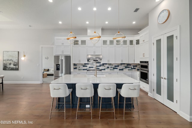 742 Honey Blossom Rd, Saint Johns, FL 32259 - kitchen with appliances with stainless steel finishes, light countertops, decorative backsplash, a large island with sink, and under cabinet range hood