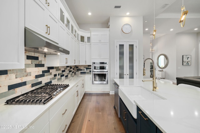 742 Honey Blossom Rd, Saint Johns, FL 32259 - kitchen featuring appliances with stainless steel finishes, light countertops, a sink, white cabinets, and under cabinet range hood