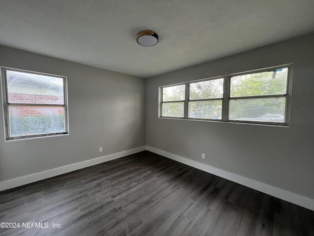 2535 Rogero Rd, Jacksonville, FL 32211 - spare room featuring baseboards and dark wood-style flooring