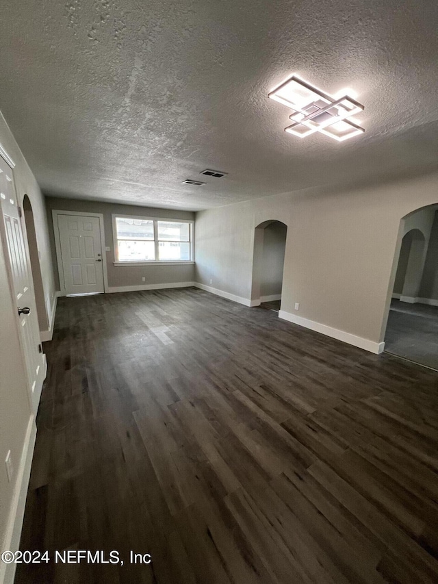 2535 Rogero Rd, Jacksonville, FL 32211 - interior space featuring baseboards, arched walkways, a textured ceiling, and dark wood-type flooring