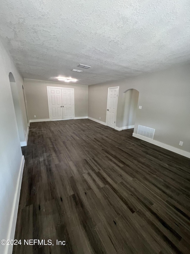 2535 Rogero Rd, Jacksonville, FL 32211 - interior space featuring arched walkways, baseboards, dark wood-style flooring, and visible vents
