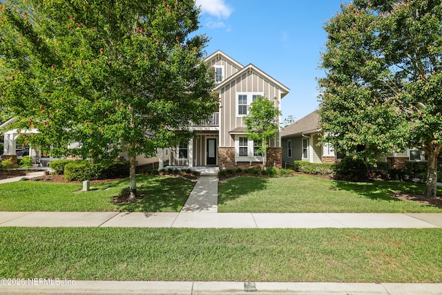 craftsman inspired home featuring board and batten siding, a front lawn, and brick siding