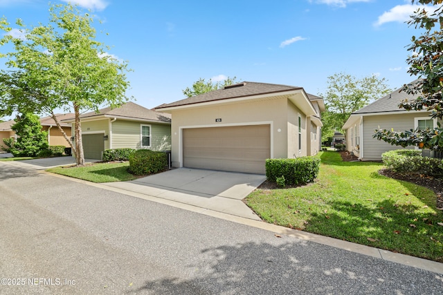 ranch-style home featuring an attached garage, a front lawn, driveway, and stucco siding