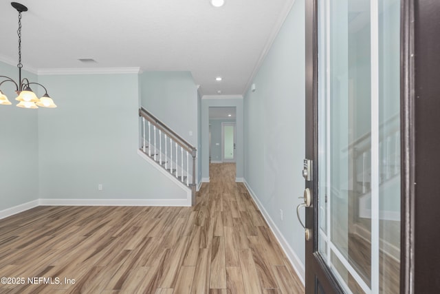 entrance foyer featuring crown molding, stairs, baseboards, a chandelier, and light wood-style flooring