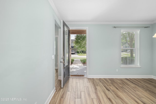 doorway with baseboards, ornamental molding, and light wood-type flooring